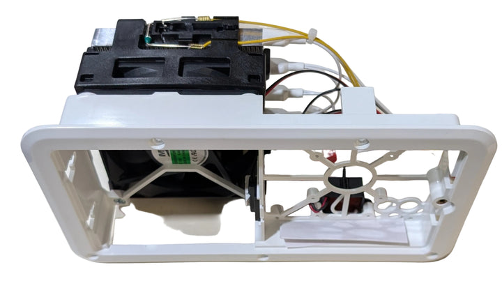 A white plastic replacement housing or frame component with attached black internal parts, wiring, and a small fan, photographed on a plain white background.